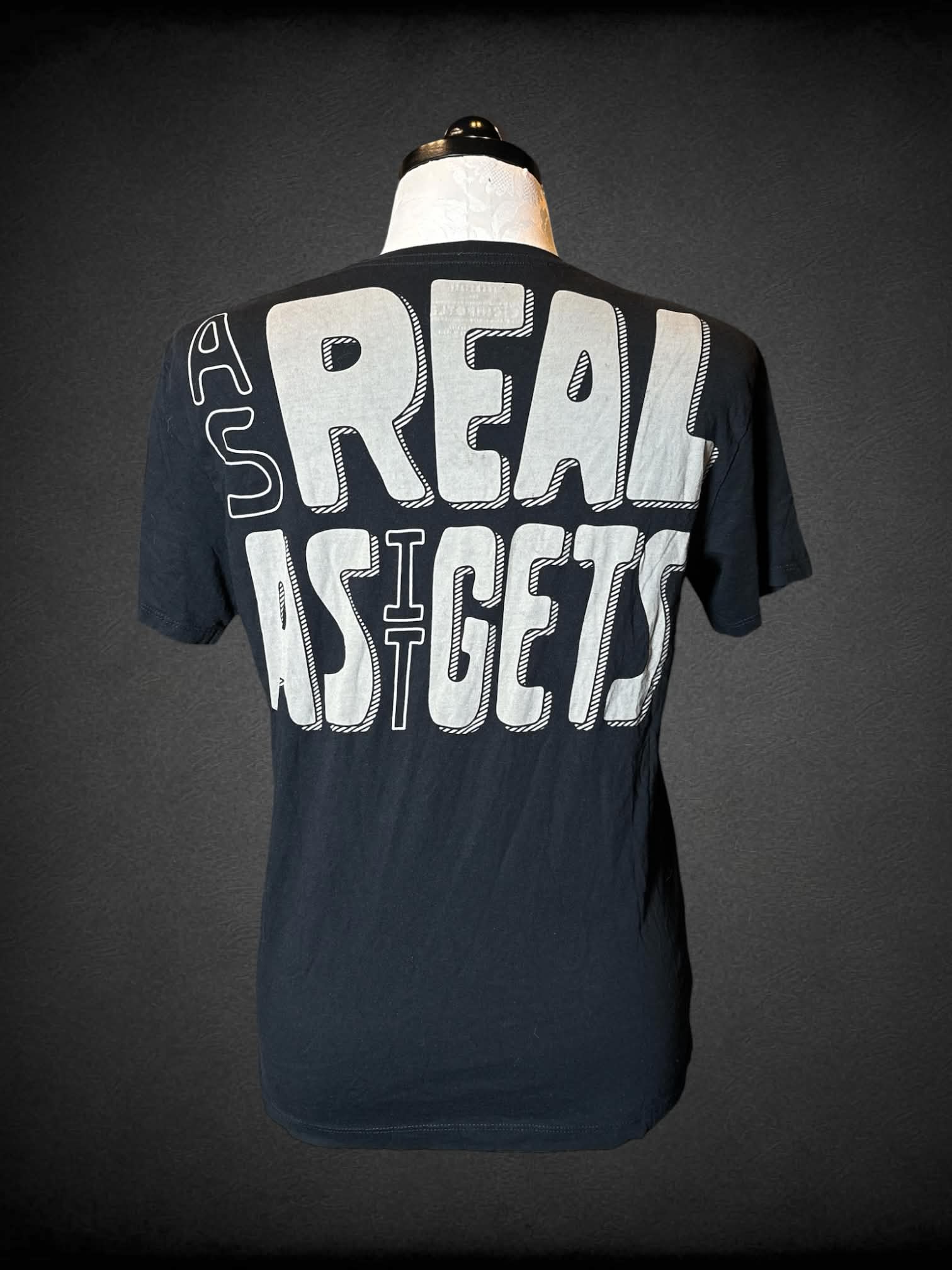 1X Loomstate black t shirt with “Chipotle” logo on front and “As Real As It Gets” writing on back