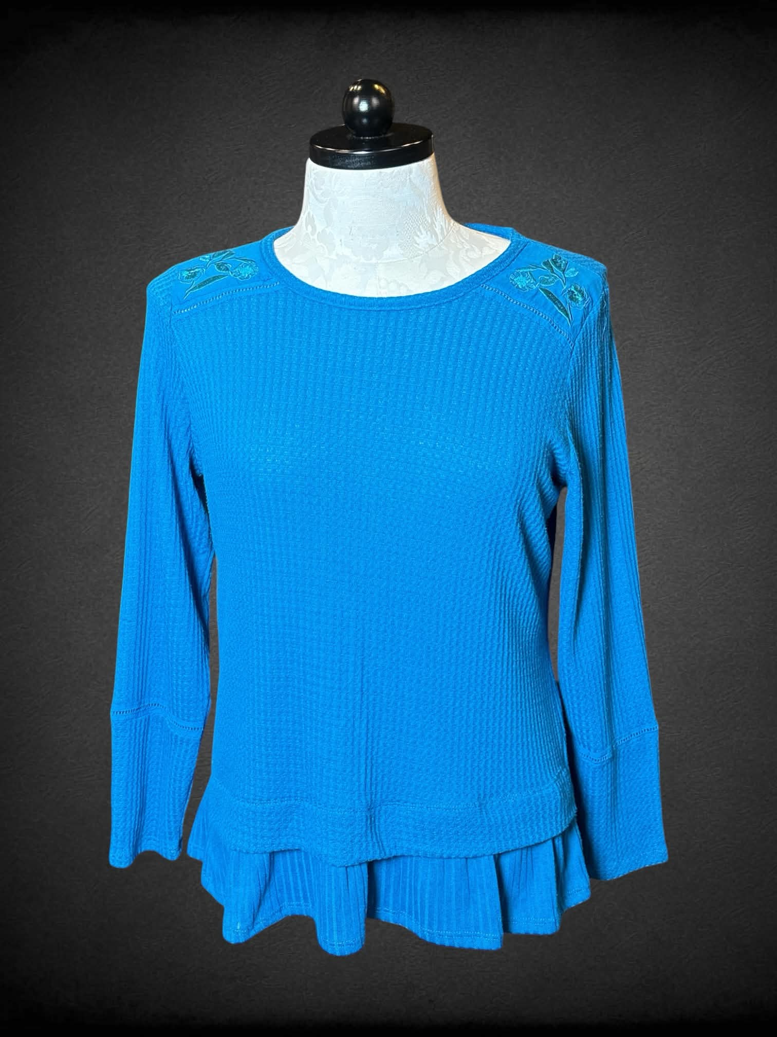 XL Isela blue knit long-sleeve sweater top with embroidered floral design on shoulders, and ruffle hem