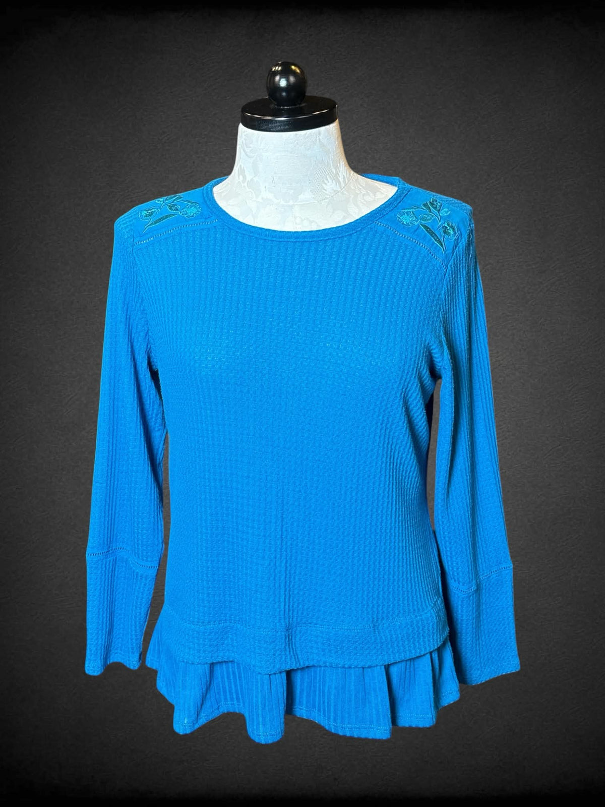 XL Isela blue knit long-sleeve sweater top with embroidered floral design on shoulders, and ruffle hem