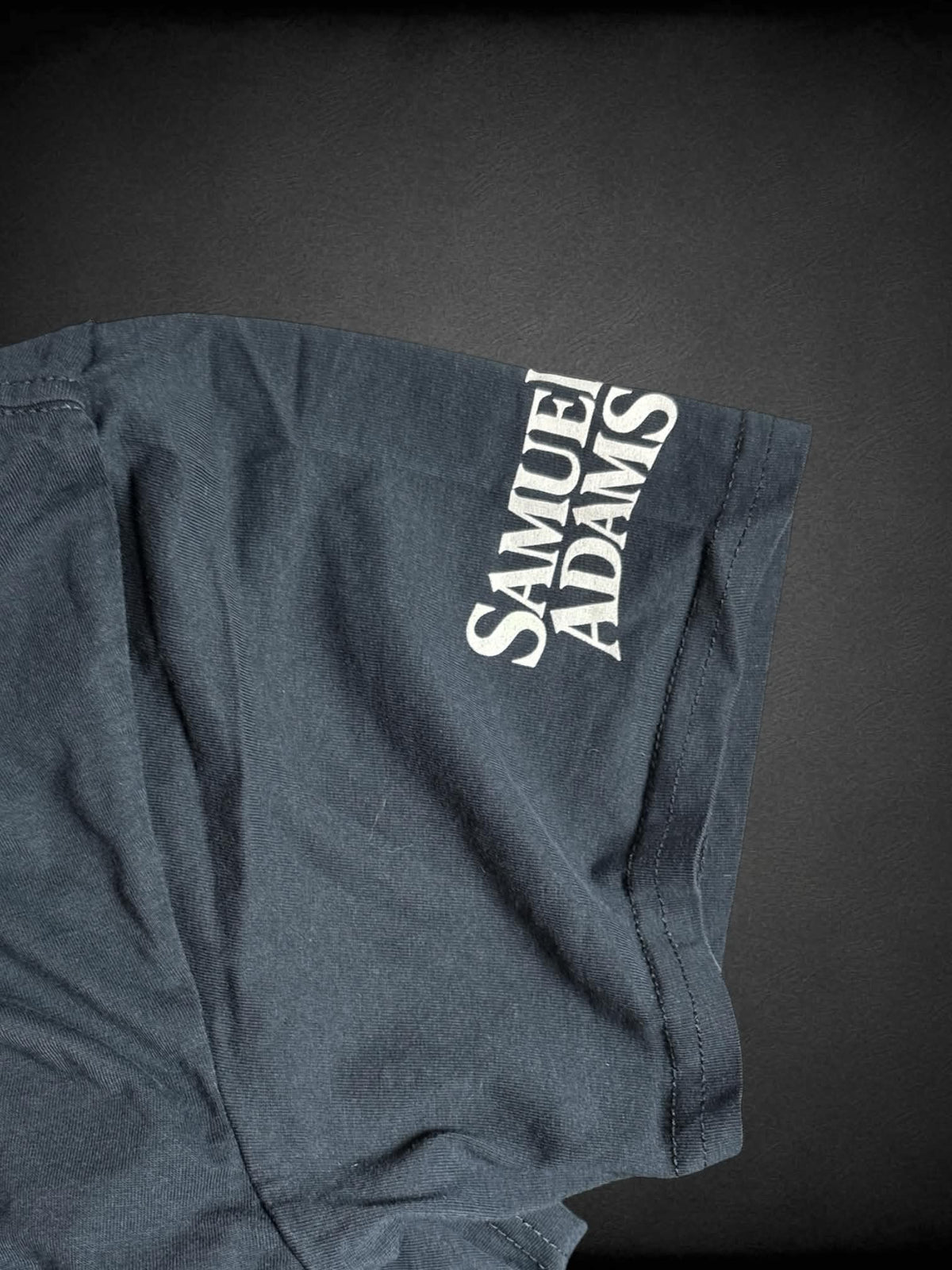 1X Samuel Adams black cropped t shirt with “For The Love of Boston” flag graphic on front, and “Samuel Adams” logo on sleeve