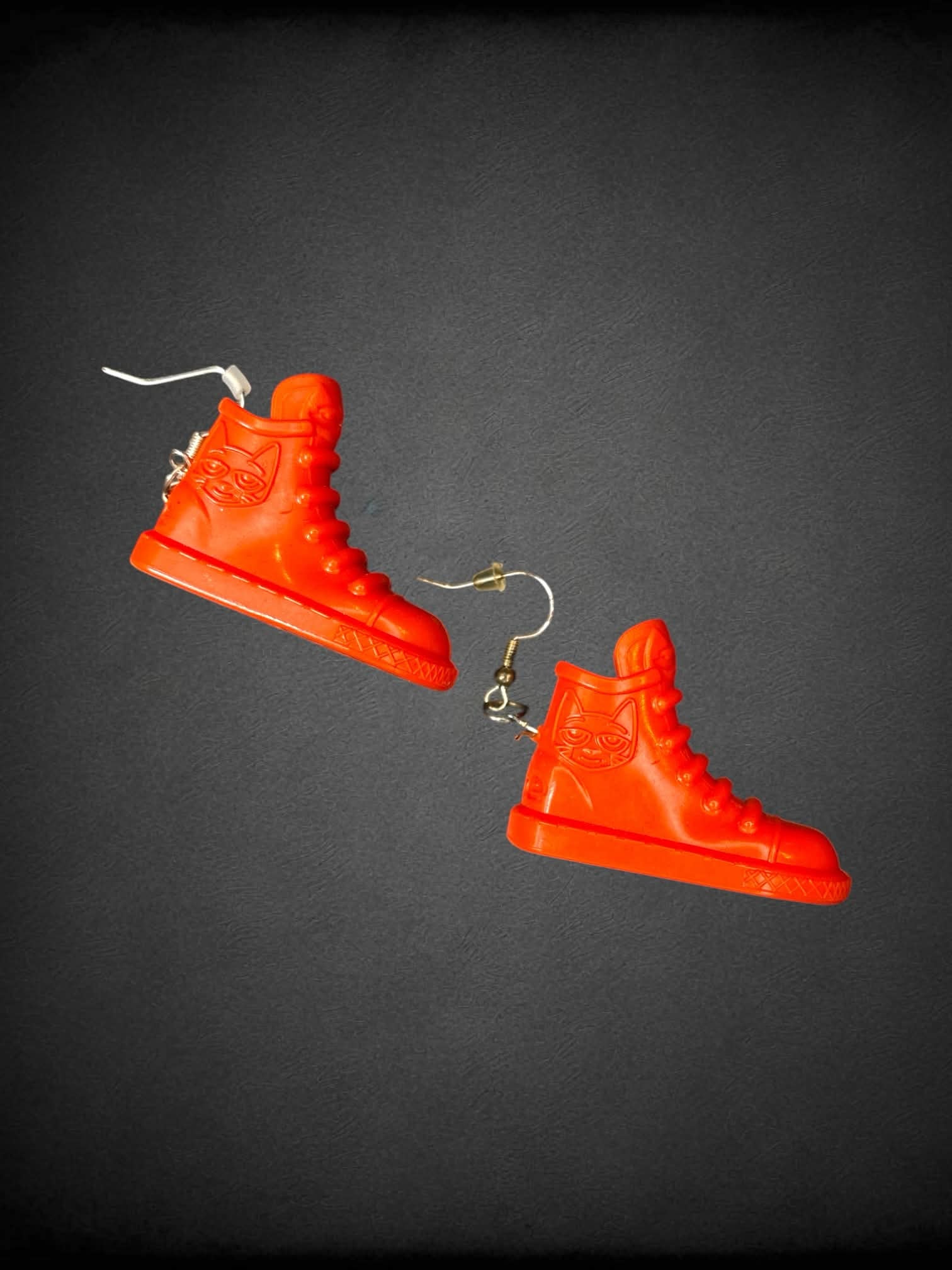Orange plastic shoe earrings with “Pete The Cat” character