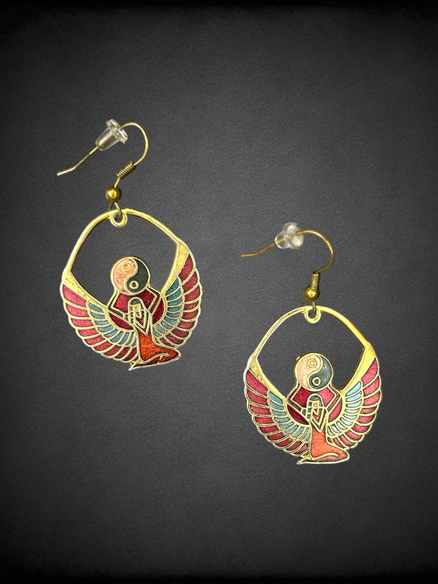 Gold Egyptian revival earrings with winged goddess holding a yin-yang symbol