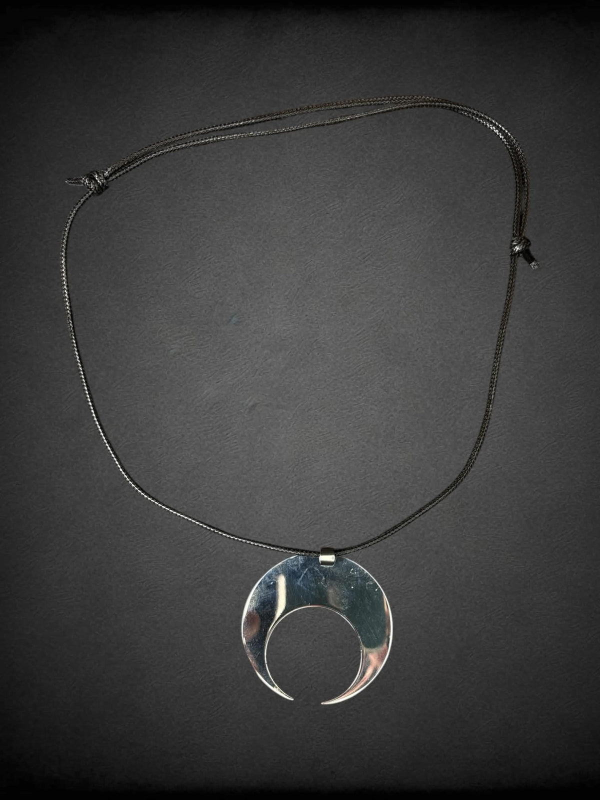 Tunnel Vision black cord necklace with metallic moon charm