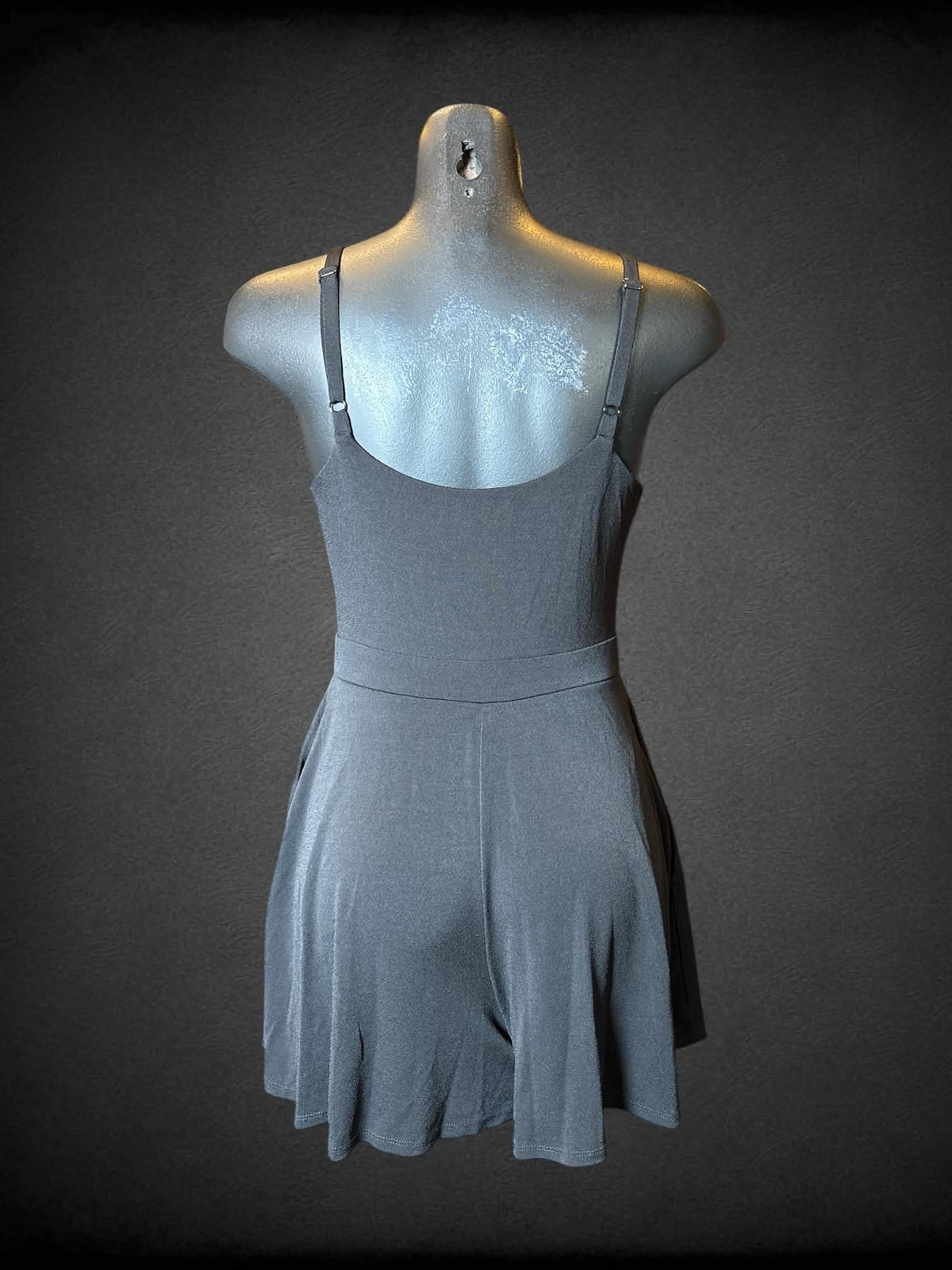 M Candie’s black jumpsuit with pockets, adjustable straps, and cinched design on front