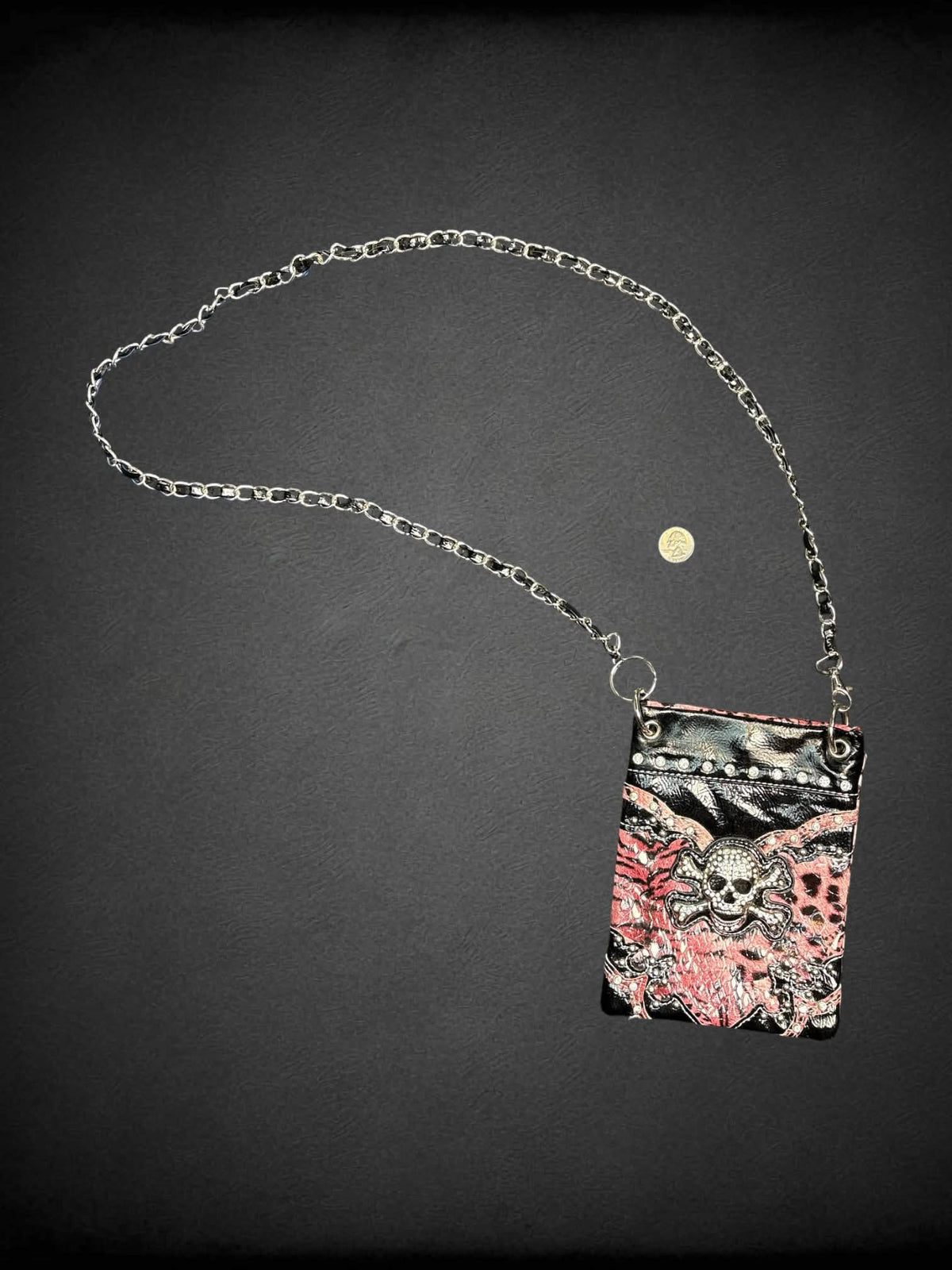 Black & pink faux leather shoulder bag with animal print pattern, bejeweled skull on front, chain strap and snap button pocket