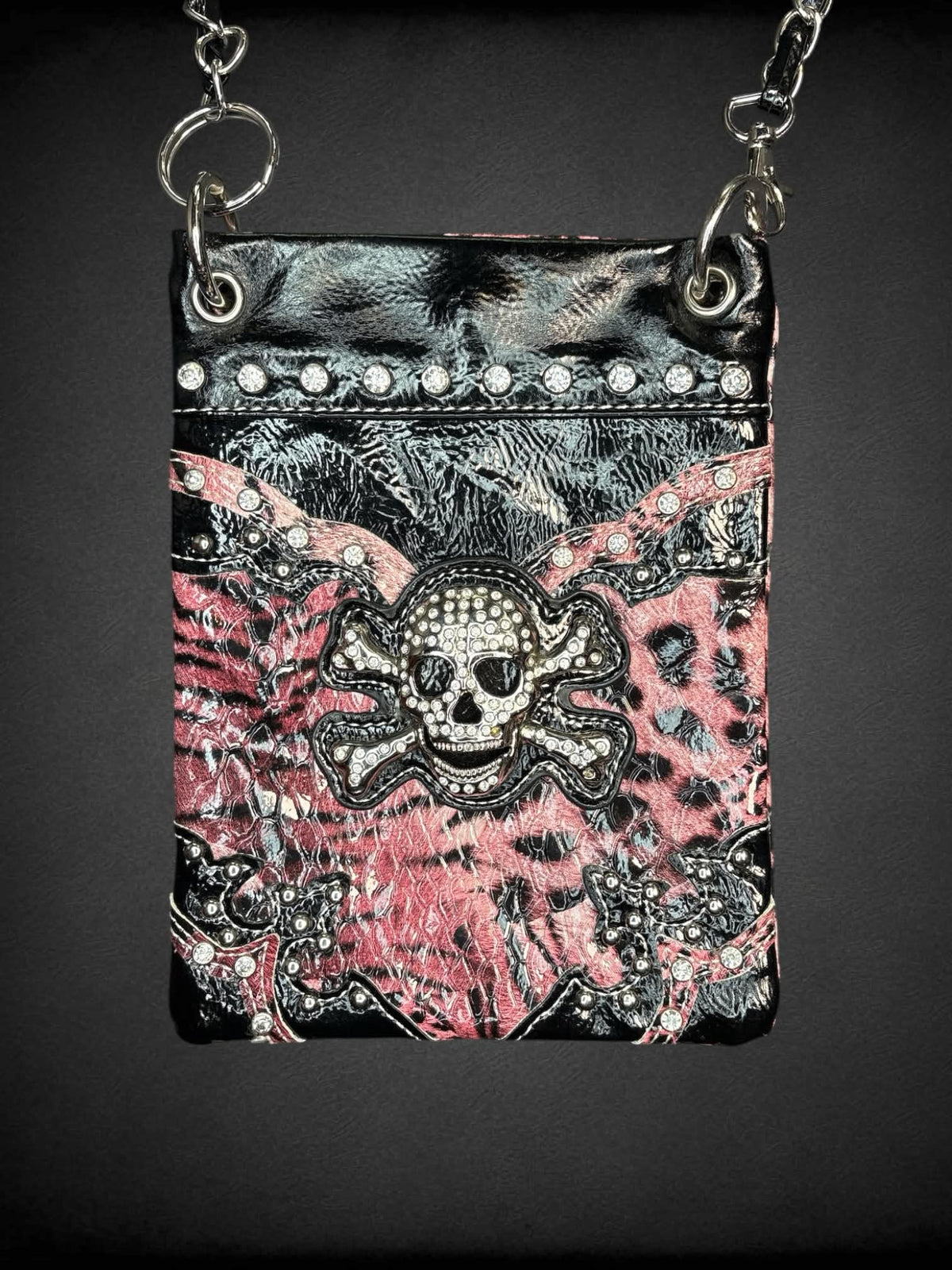 Black & pink faux leather shoulder bag with animal print pattern, bejeweled skull on front, chain strap and snap button pocket