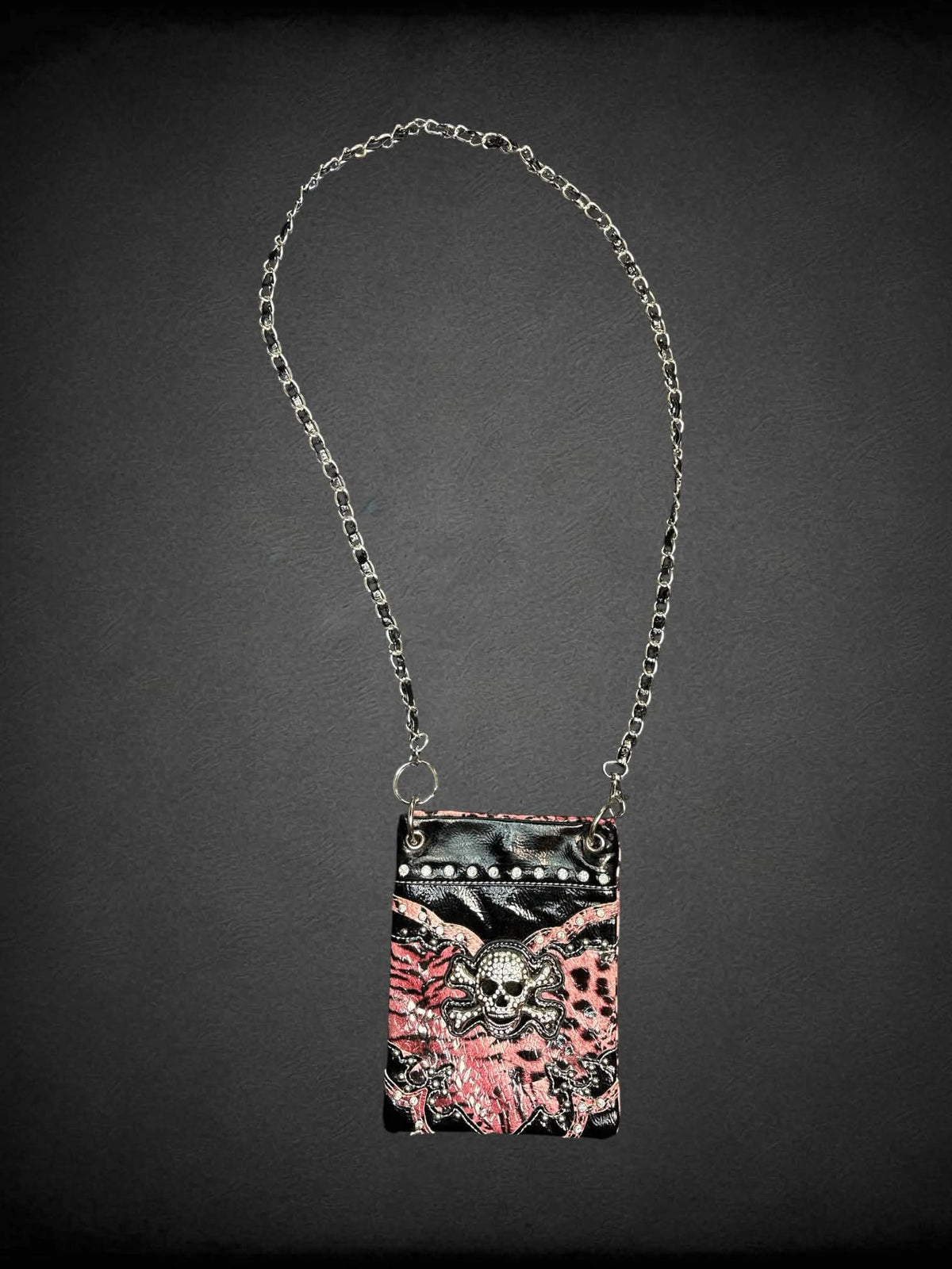Black & pink faux leather shoulder bag with animal print pattern, bejeweled skull on front, chain strap and snap button pocket