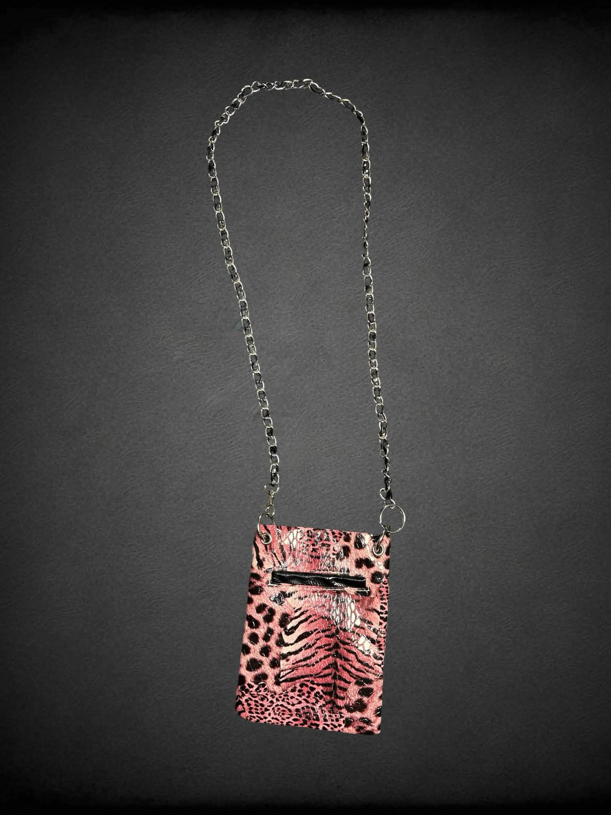 Black & pink faux leather shoulder bag with animal print pattern, bejeweled skull on front, chain strap and snap button pocket