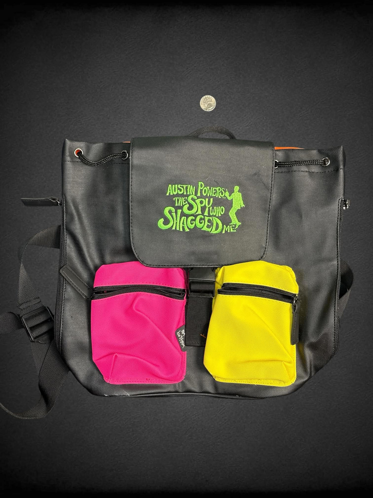 Austin Powers black color block backpack with embroidered “Austin Powers: The Spy Who Shagged Me” on front, and zipper pockets