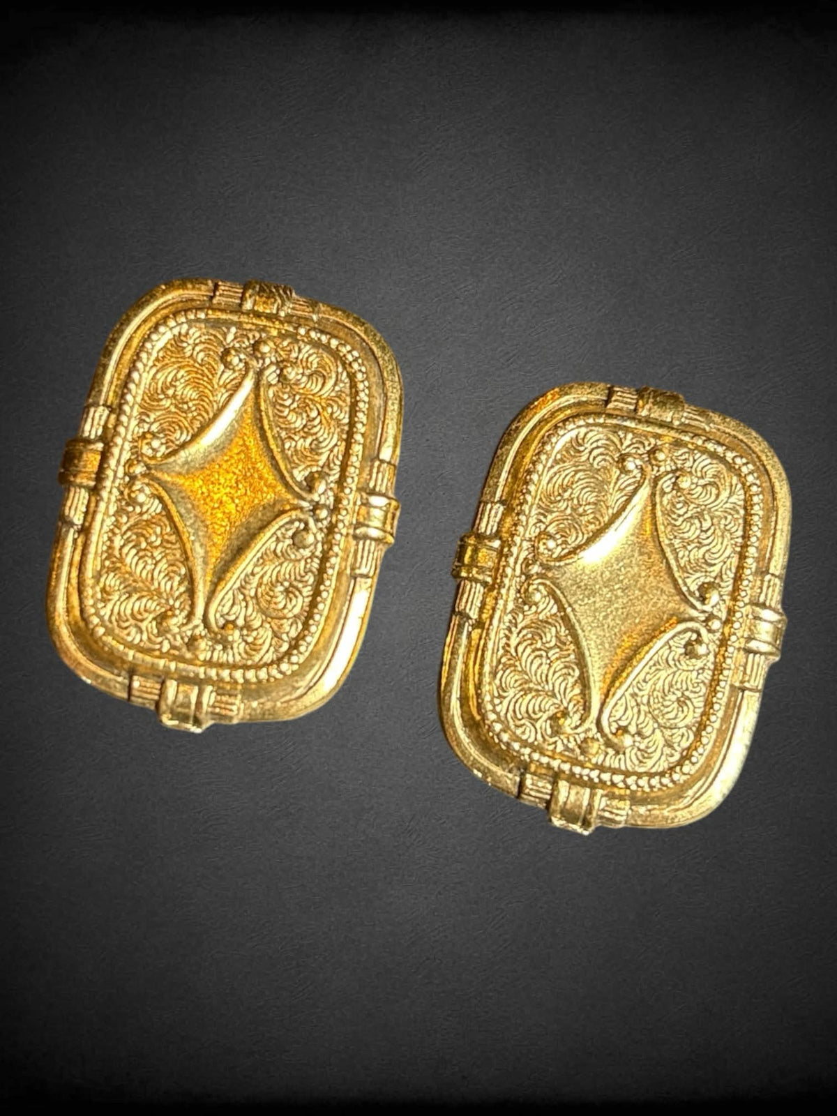 Gold tone flat earrings with ornate design