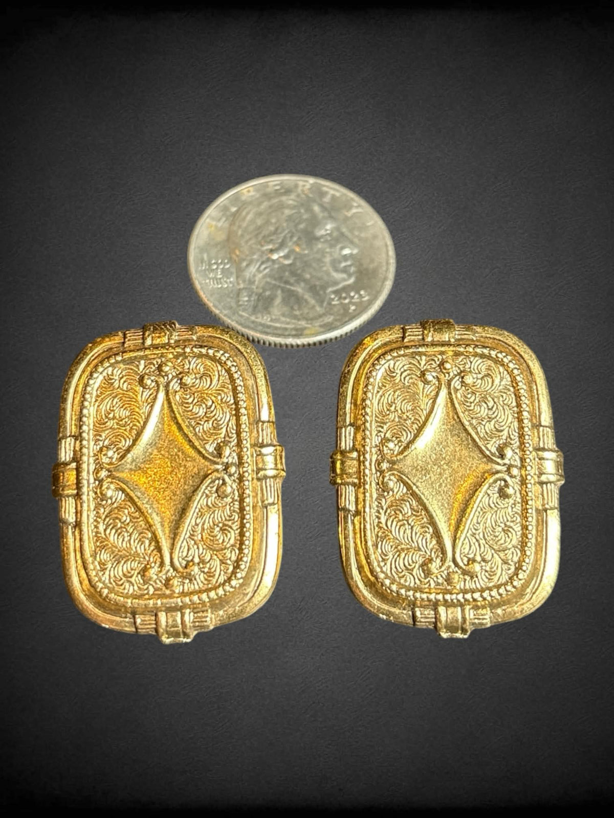 Gold tone flat earrings with ornate design