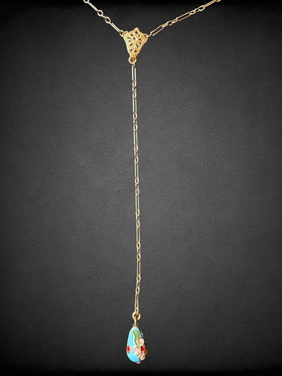 Gold tone necklace with dangling blue beaded pendant