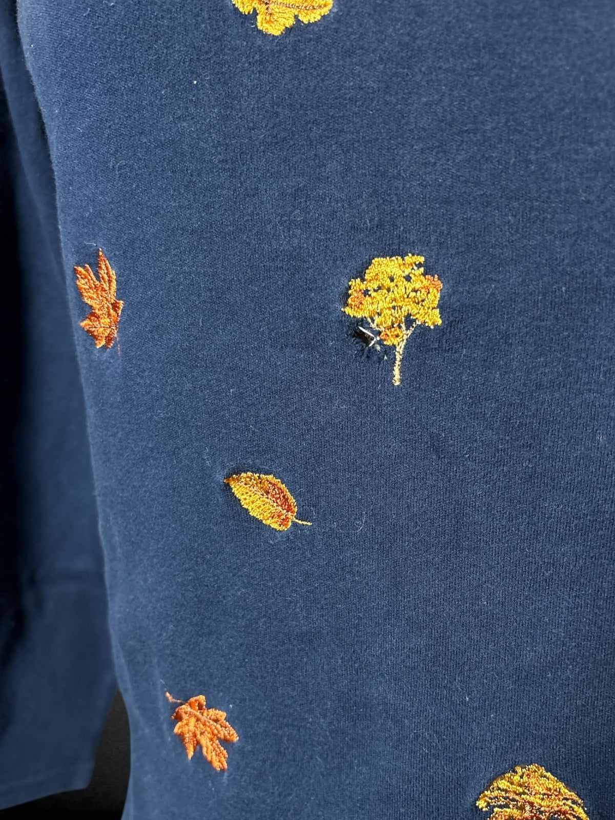 0X Studio Works navy long-sleeve turtleneck shirt with embroidered autumn tree design on front