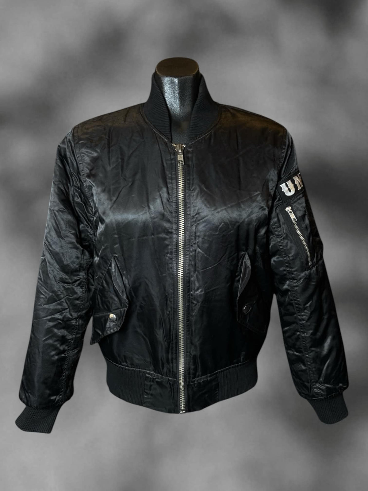 M UNIF black zip-up bomber jacket with “Whatever” skeleton hands graphic on back, and pockets