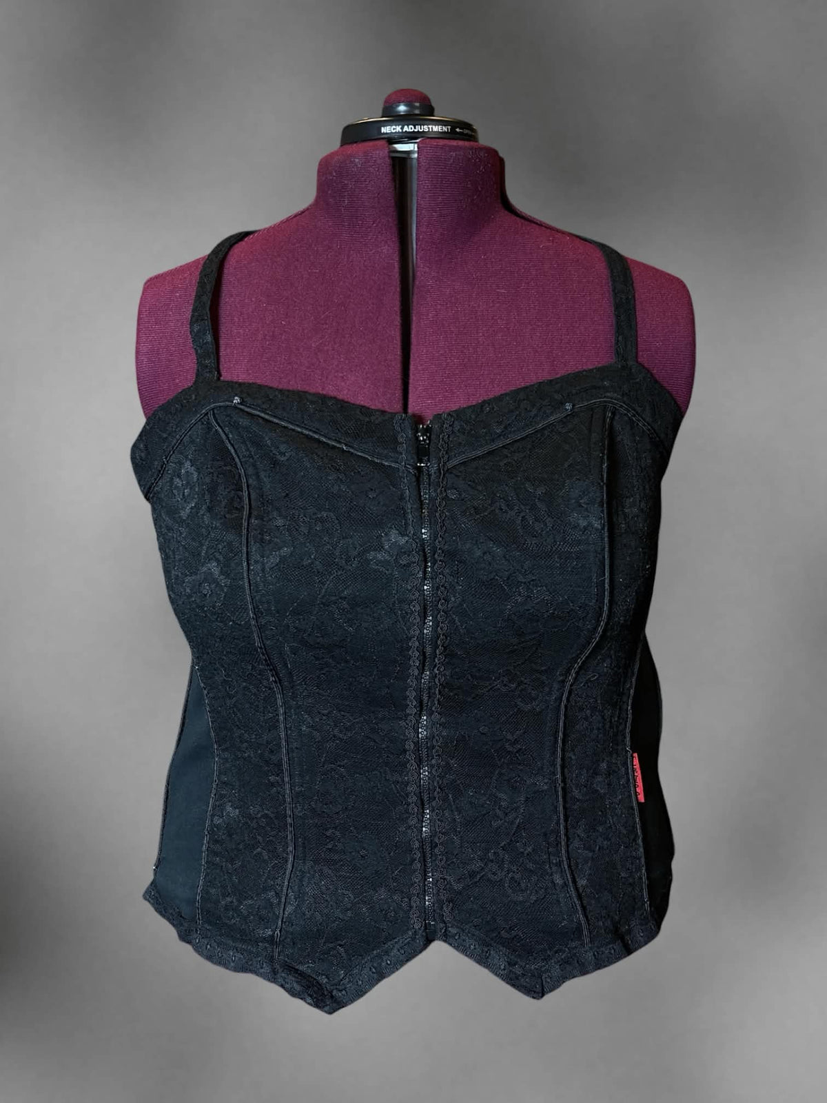 2X Tripp NYC designer Y2K black corset top with floral lace design, zipper on front, and cross straps