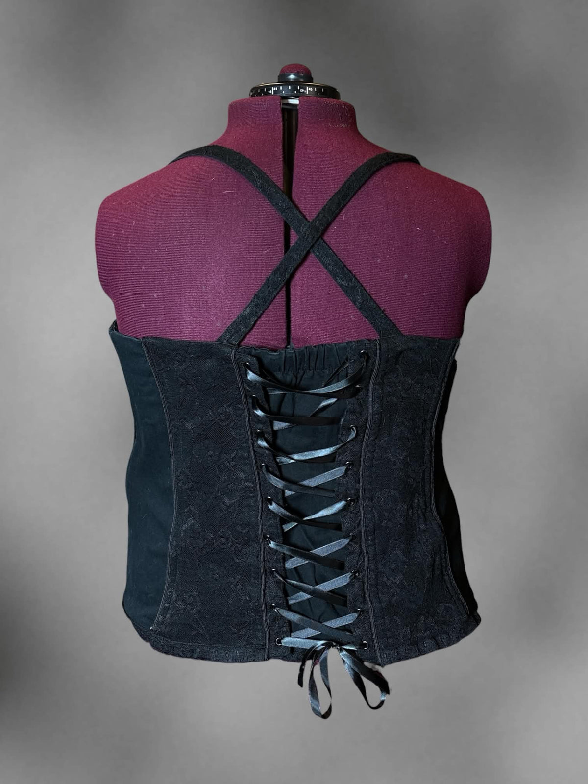 2X Tripp NYC designer Y2K black corset top with floral lace design, zipper on front, and cross straps