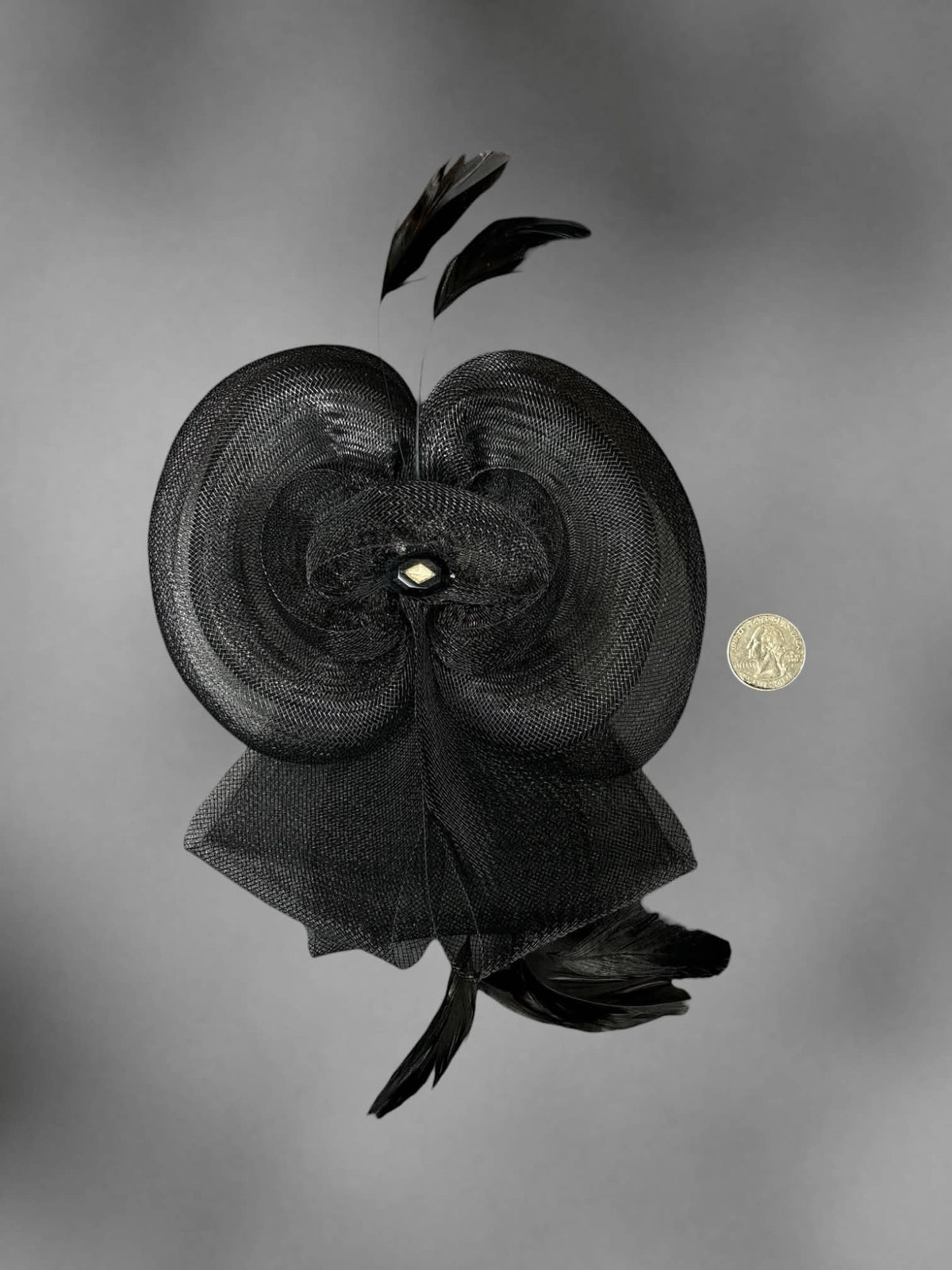 Black mesh bow hair clip with decorative feathers