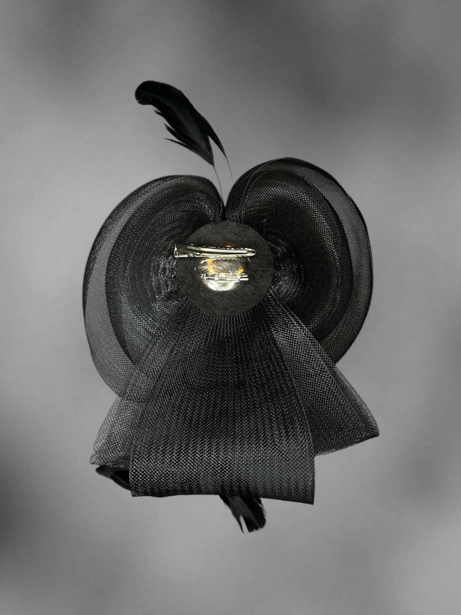 Black mesh bow hair clip with decorative feathers
