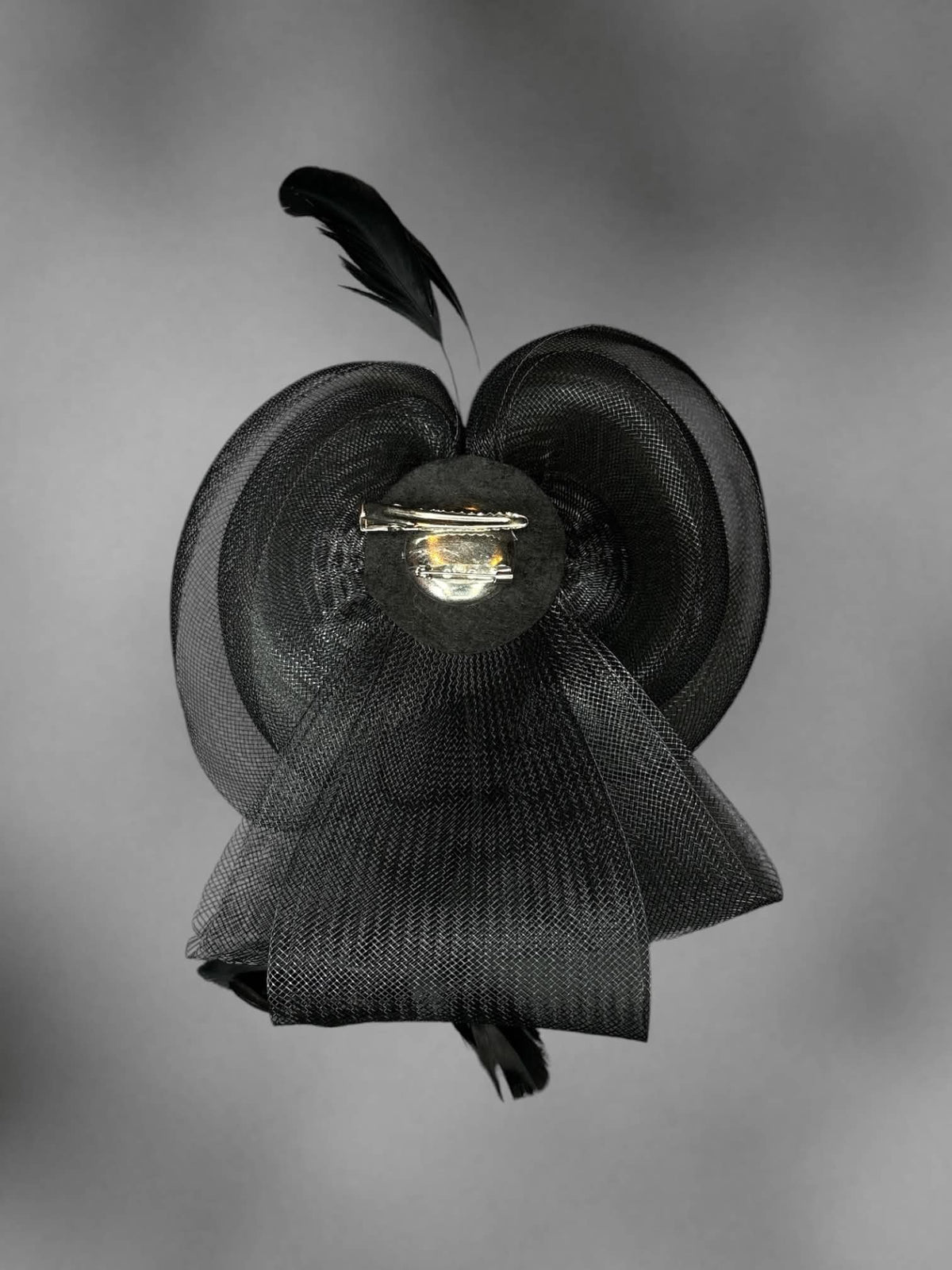 Black mesh bow hair clip with decorative feathers