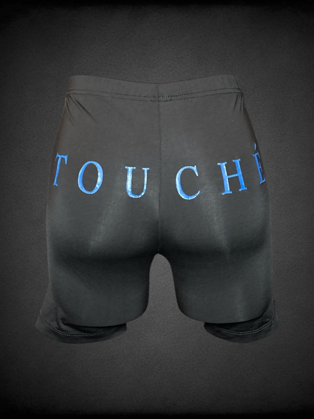 S Champion black athletic spandex shorts with “Touché” writing across back