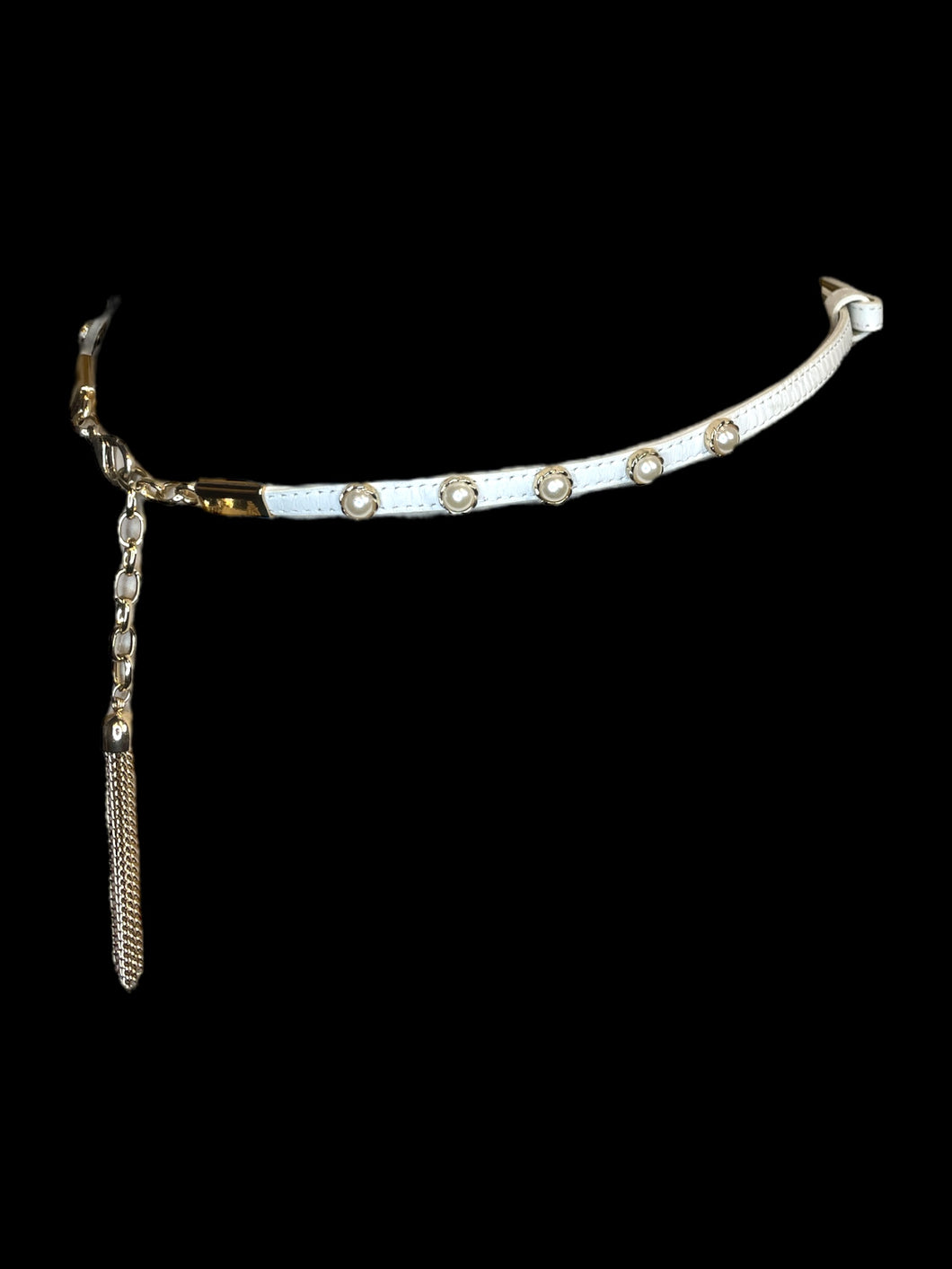 M White faux leather thin waist belt w/ gold like hardware, faux pearl details, adjustable lobster claw clasp & chain, adjustable peg & hole detail, & gold-like chain tassle