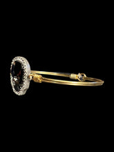 Load image into Gallery viewer, Gold like wire bracelet w black skull shaped gem, white gem outline, &amp; hook/loop closure
