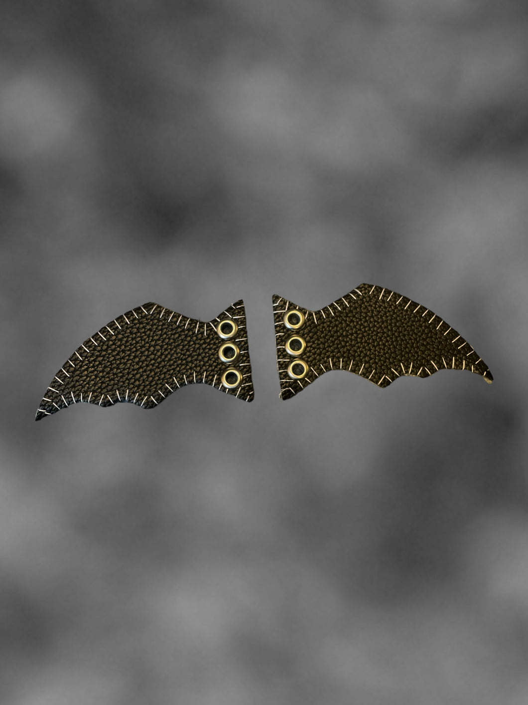 Black pleather bat wing shoe accessory w/ metal eyelets, & white stitching