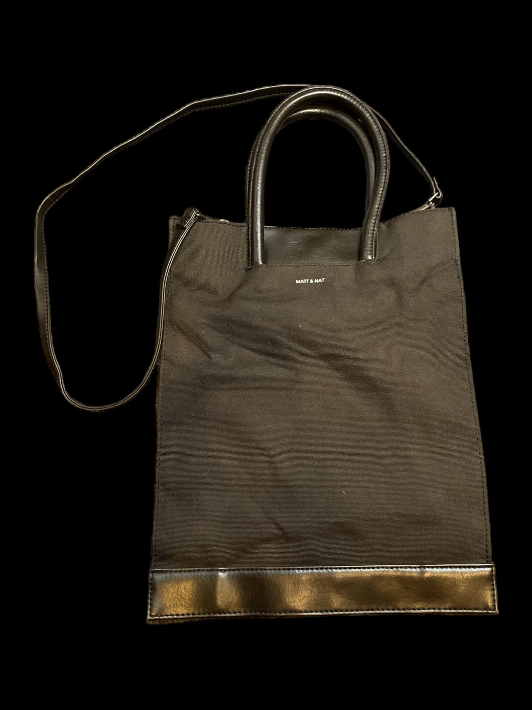 Black canvas & faux leather tote bag w/ removable cross body strap, magnetic clasp, & inner pockets
