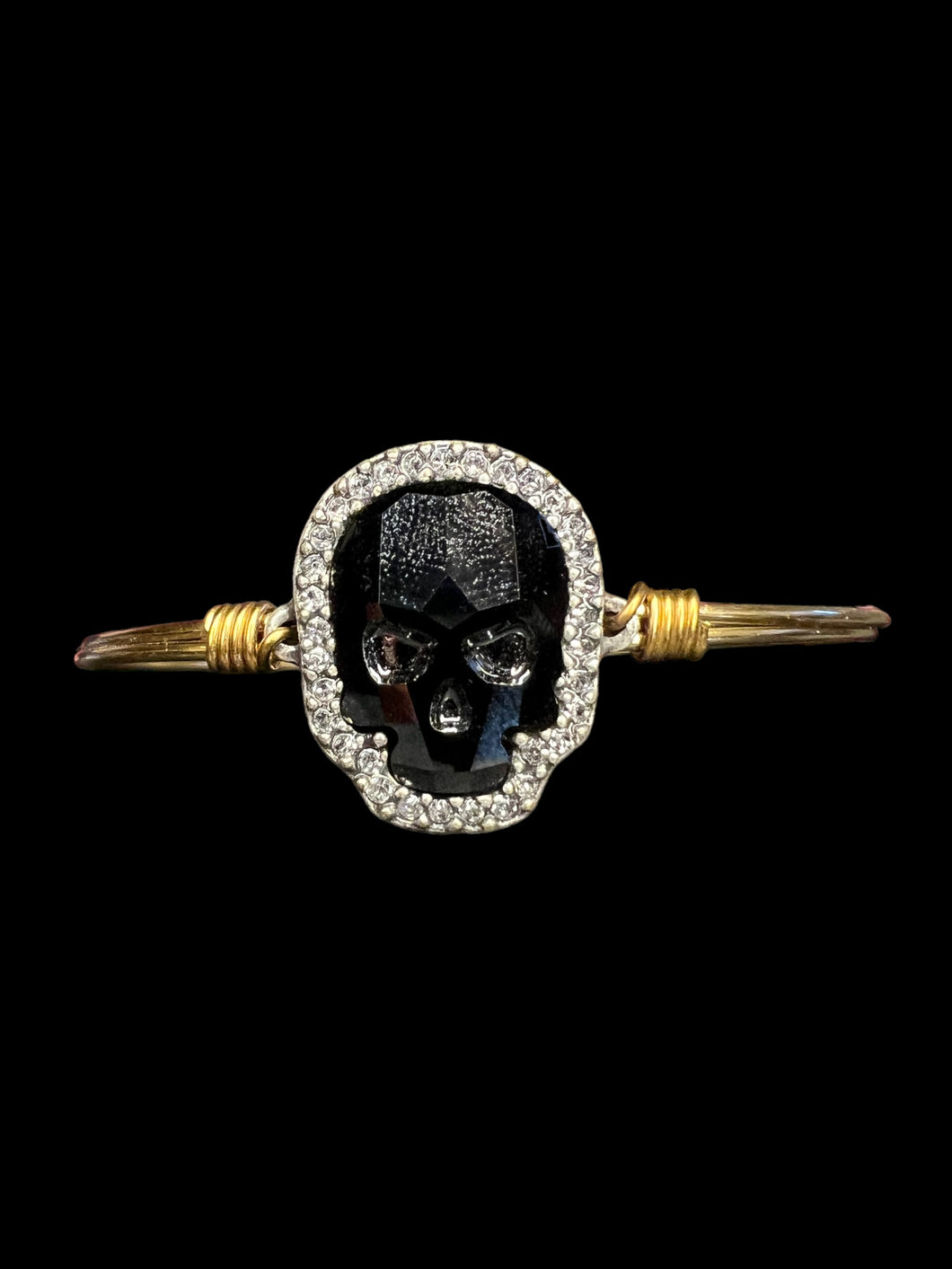 Gold like wire bracelet w black skull shaped gem, white gem outline, & hook/loop closure